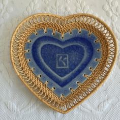 a blue heart shaped dish on a doily