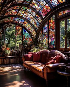 a living room filled with lots of windows covered in colorful stained glass panels and furniture