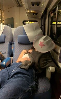 a man laying on top of a blue seat next to a woman wearing a cowboy hat