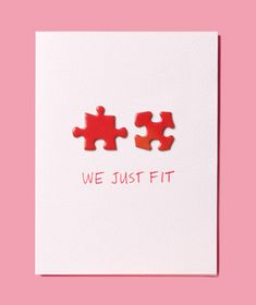 two pieces of red puzzle sitting on top of a white card that says, we just fit