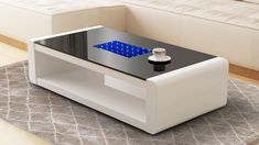 a coffee table with a blue light on it in front of a couch and rug