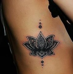 a woman's stomach with a lotus tattoo on it