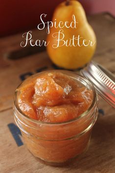 a glass jar filled with food sitting on top of a wooden table next to an apple