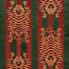 an orange tiger on green and red striped rug with black stripes in the background,