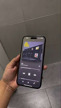 someone is holding up their cell phone to take a photo with the music player on it