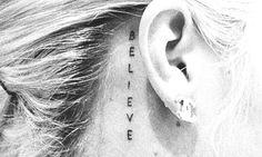 the back of a woman's ear with words written on it