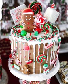 a christmas cake decorated with gingerbreads, candies and candy canes on a table