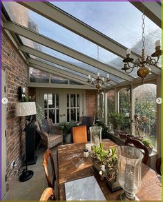 a dining room with a table and chairs under a glass roof over looking a patio