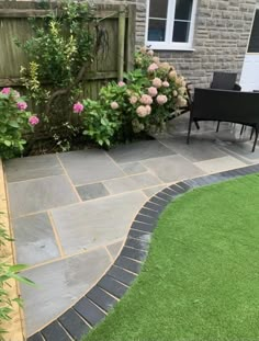 an outdoor patio area with grass and flowers