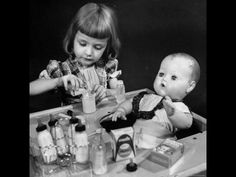 two young children sitting at a table with bottles