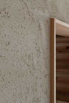 a close up of a wall with a shelf in the corner and wood trim around it