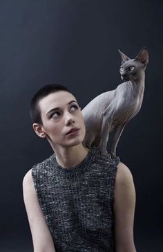 a woman with a cat on her shoulders