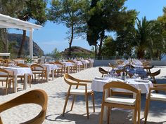 tables and chairs are set up on the beach