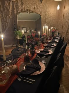 a long dining table set with candles and plates