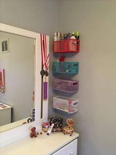 a white dresser sitting next to a mirror in a room with toys on top of it