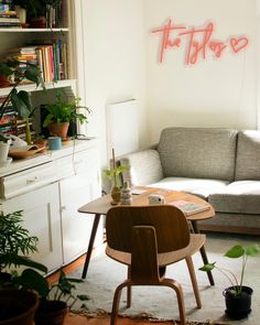 a living room filled with furniture and lots of plants