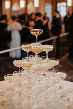 there are many wine glasses stacked on top of each other in the middle of a table