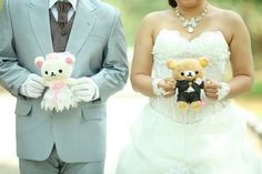 the bride and groom are holding teddy bears