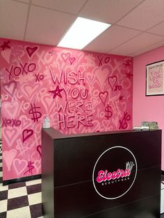 a pink and black checkered floor with graffiti on the wall