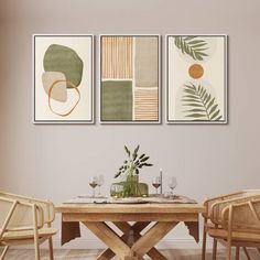 three paintings hang above a dining room table