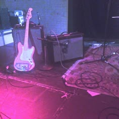 two guitars and amps are sitting on the floor