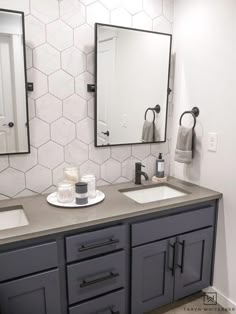 a bathroom with two sinks and mirrors on the wall