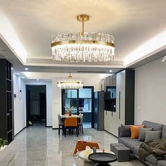 a living room filled with furniture and a chandelier hanging above the couches