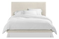 a bed with white linens and pillows on it's headboard, against a white background