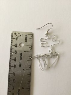 a pair of earrings sitting next to a ruler