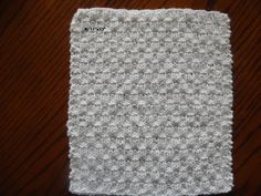 a crocheted dishcloth sitting on top of a wooden table