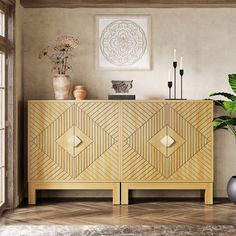 a large wooden cabinet sitting next to a potted plant on top of a hard wood floor