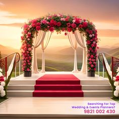 an outdoor ceremony with flowers and red carpet on the steps leading up to the stage