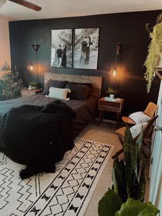 a bedroom with black walls and white rugs on the floor, two pictures above the bed