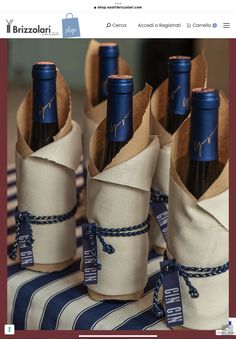 four wine bottles wrapped in burlocks on top of a table