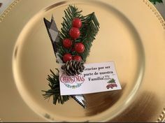 a gold plate with a christmas decoration on it and a card attached to the edge