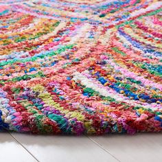 a multicolored rug on the floor with white wooden floors and light colored carpet