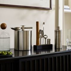 a kitchen counter topped with metal containers and utensils