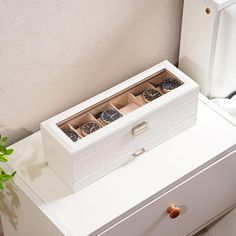 a white chest with three watches in it