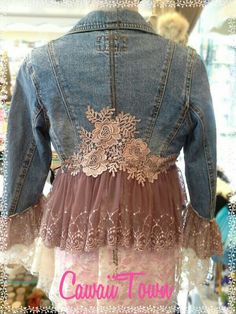 the back of a jean jacket with lace and flower appliqued on it