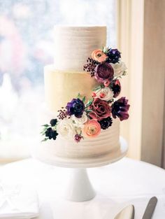 a three tiered cake with flowers on the top is displayed in an instagram