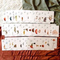 four cards with different types of animals on them sitting on a bed next to each other