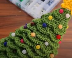 a green crocheted christmas tree sitting on top of a wooden table