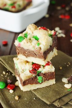 two pieces of christmas brownies stacked on top of each other with candy and marshmallows