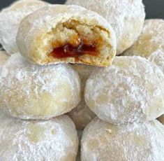 powdered sugar covered pastries stacked on top of each other with jam in the middle