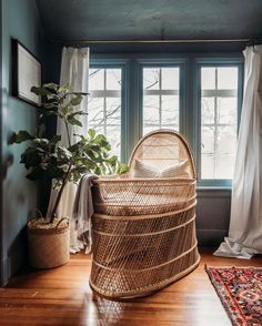 a wicker basket sitting on top of a wooden floor next to a window