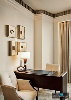 a desk and chair in a room with curtains on the window sill behind it