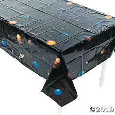 a black table cover with planets and stars on it is sitting in front of a white background