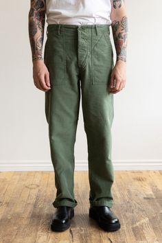 It is hard to beat a great pair of broken-in fatigue pants, but unfortunately most don't have the perfect fit. orSlow has solved this problem and then some. First, sourcing the exact fabric and then washing and working it to feel like wear ready and then cutting with a straight fit that is a perfect hybrid between a tailored trouser and the baggy originals. These are the pants you've been hunting for in vintage shops. This seasonal model features a pre-washed and distressed fabric that feels gre Green Pants Men, Green Linen Pants, Green Pants Outfit, Fatigue Pants, Distressed Fabric, Army Fatigue, Mens Linen Pants, Pants Outfit Men, Painters Pants