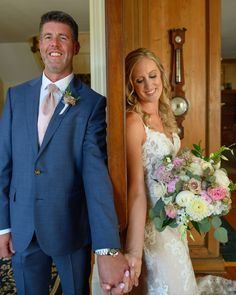 a bride and groom hold hands as they stand in front of the doorway to their wedding ceremony