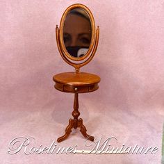 an antique wooden dressing table with a mirror on it's top and the reflection of a woman in the mirror